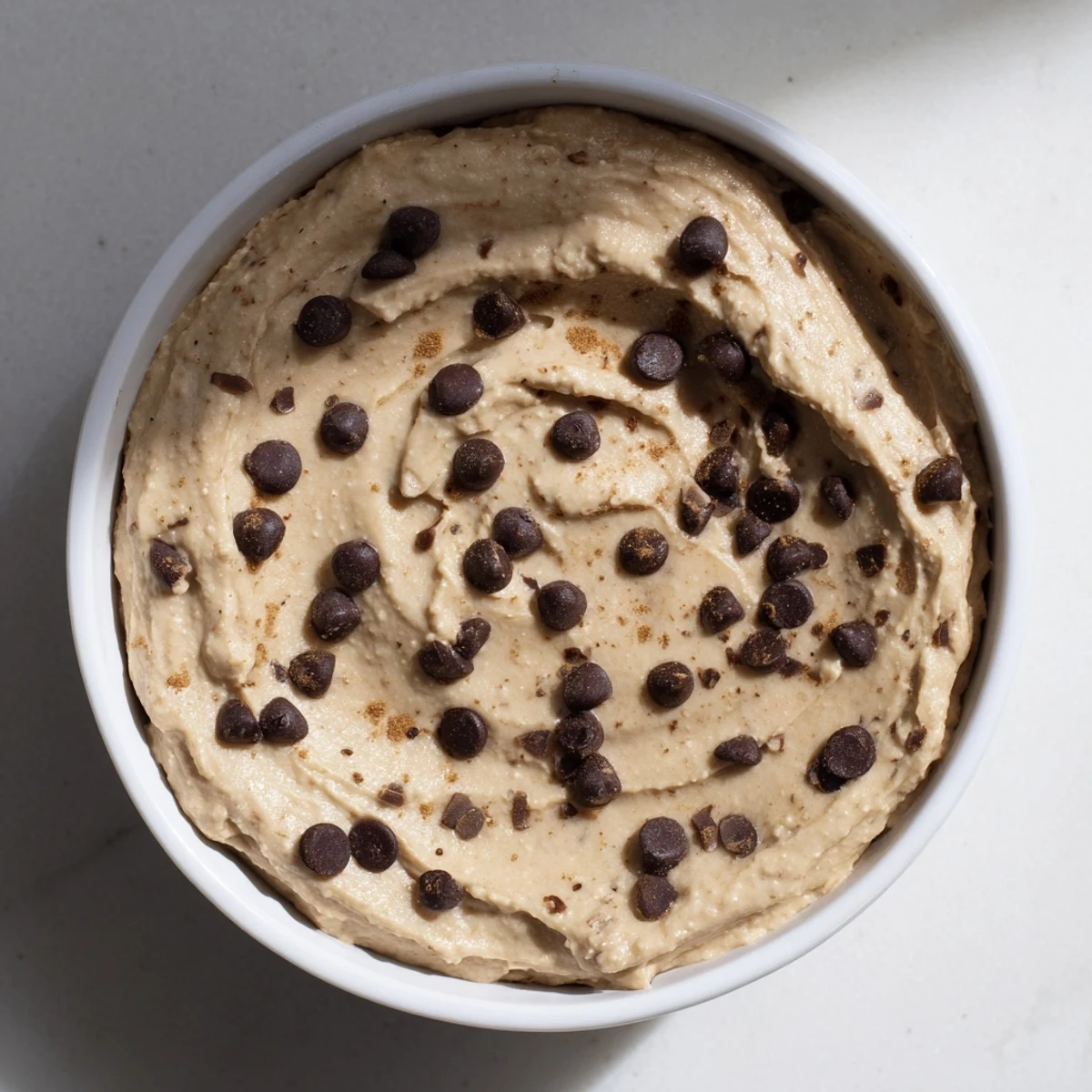 Smooth, decadent Chocolate Chip Cookie Dough Hummus, speckled with chocolate chips—a sweet treat.