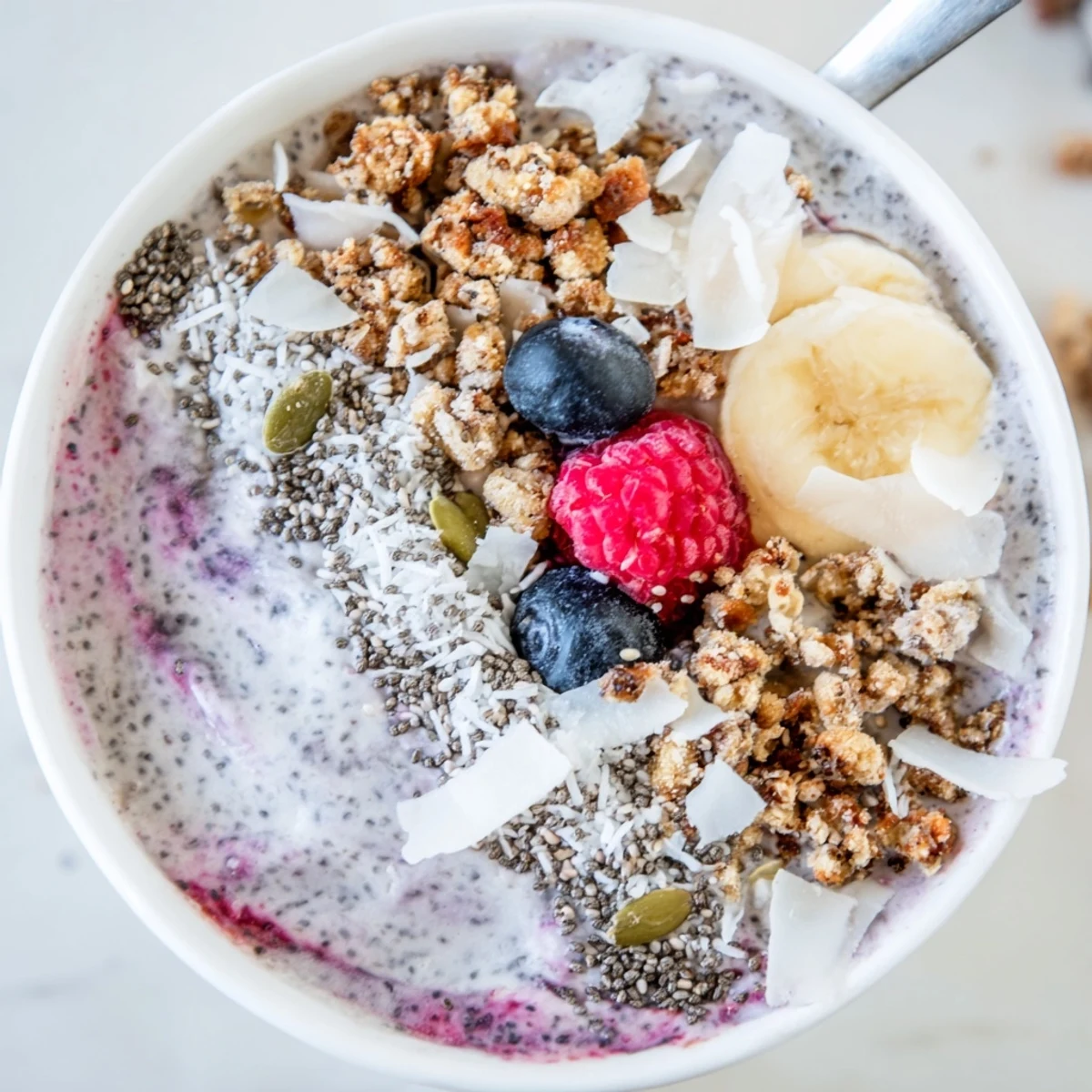 A nourishing bowl of Winter Berry Smoothie Bowl, featuring vibrant berries and a sprinkle of chia seeds for texture.