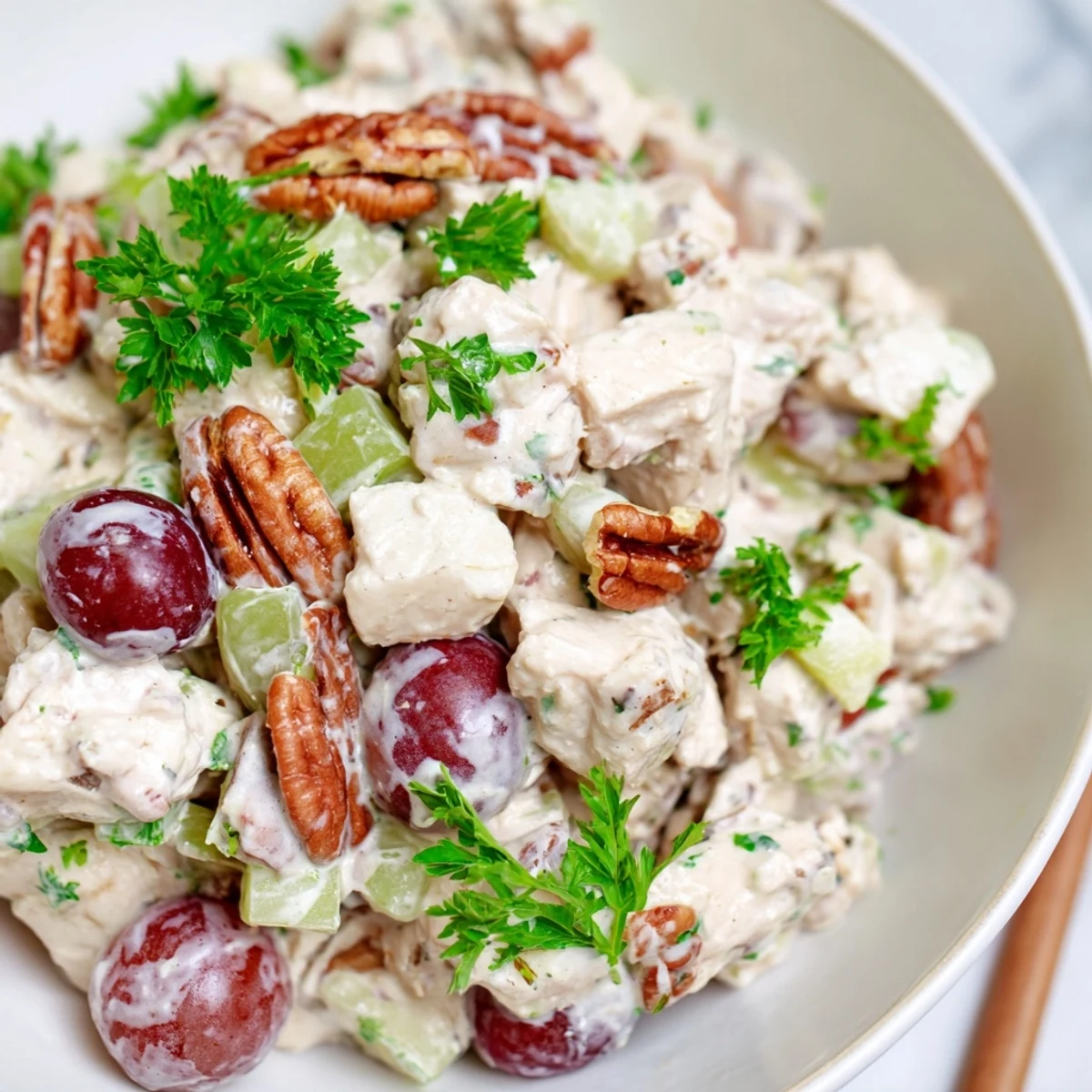 Freshly made Chicken Pecan Salad with tender chicken, creamy dressing, and crunchy pecans in a white bowl.