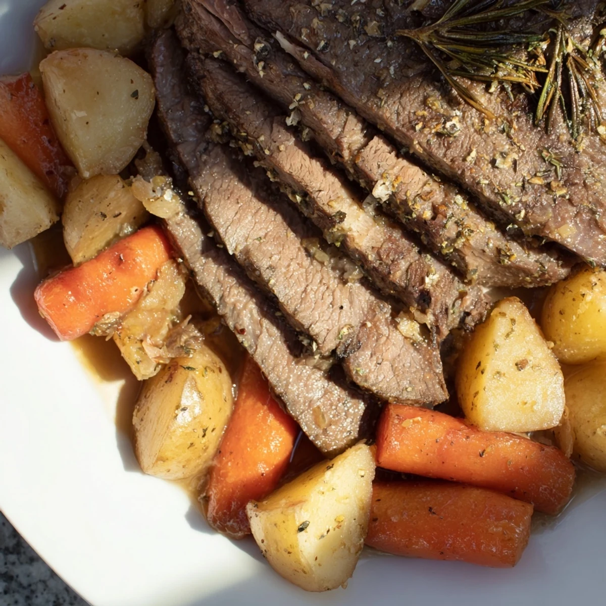 A rustic platter features sliced beef roast with roasted potatoes, carrots, and a rich gravy drizzle.