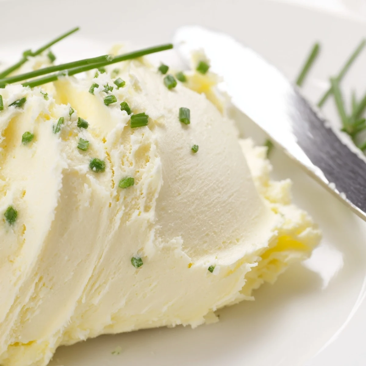 A close-up of Creamy Salted Butter on a wooden board, garnished with fresh parsley and sea salt.