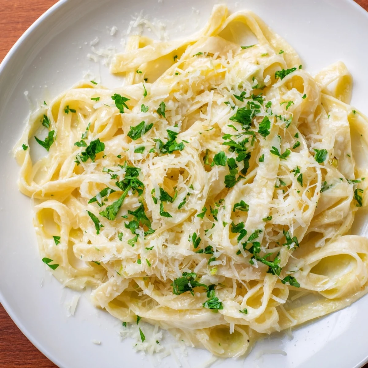 A skillet of Creamy Dinner Pasta featuring tender noodles in rich garlic cream, served with extra Parmesan.