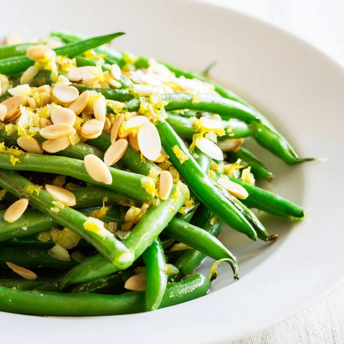 Bright, crisp-tender green beans tossed with fragrant garlic, zesty lemon juice, and golden toasted almonds in a skillet.