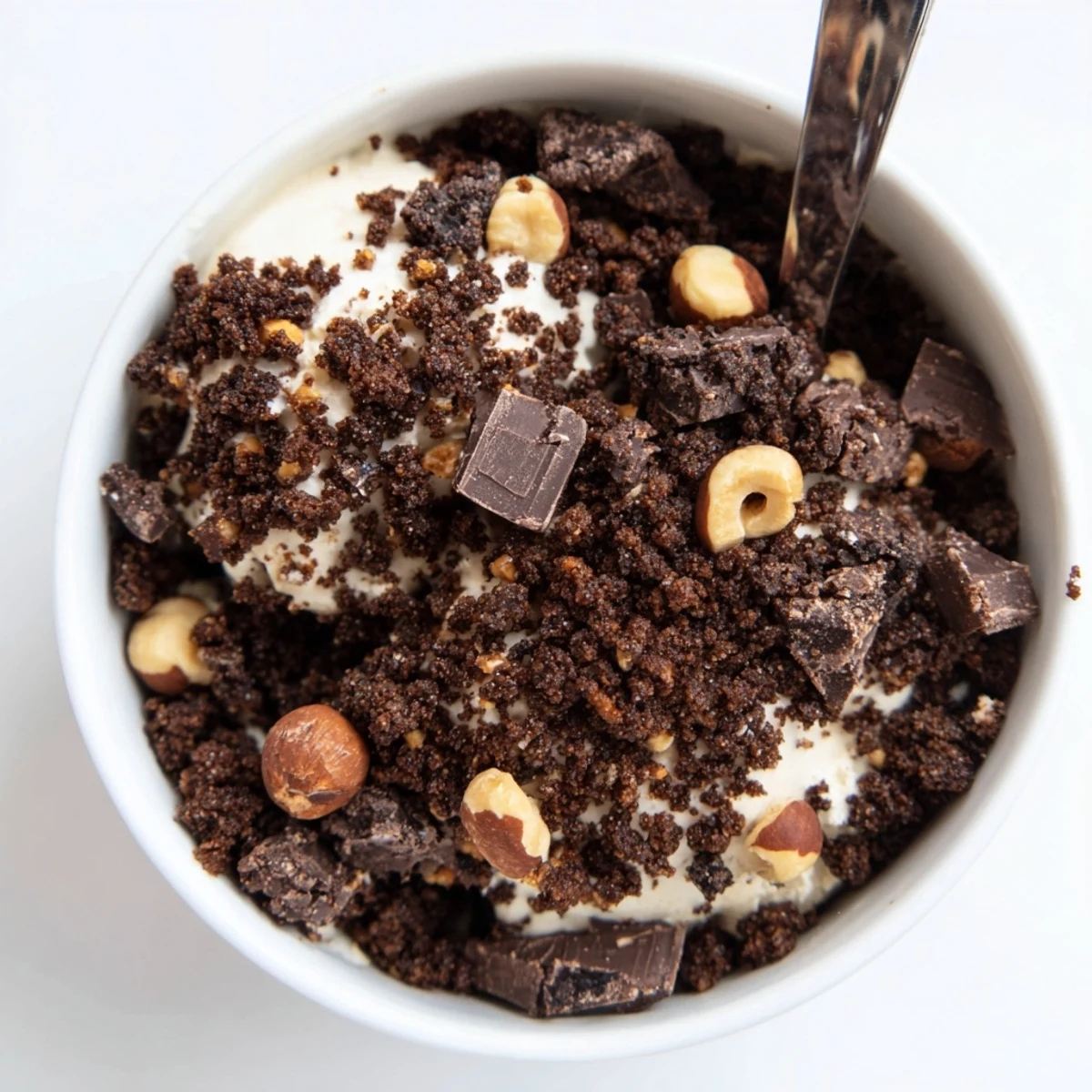 Chocolate Cookie Crumble Topping scattered over creamy vanilla ice cream, adding a rich, crunchy texture to every spoonful.  
