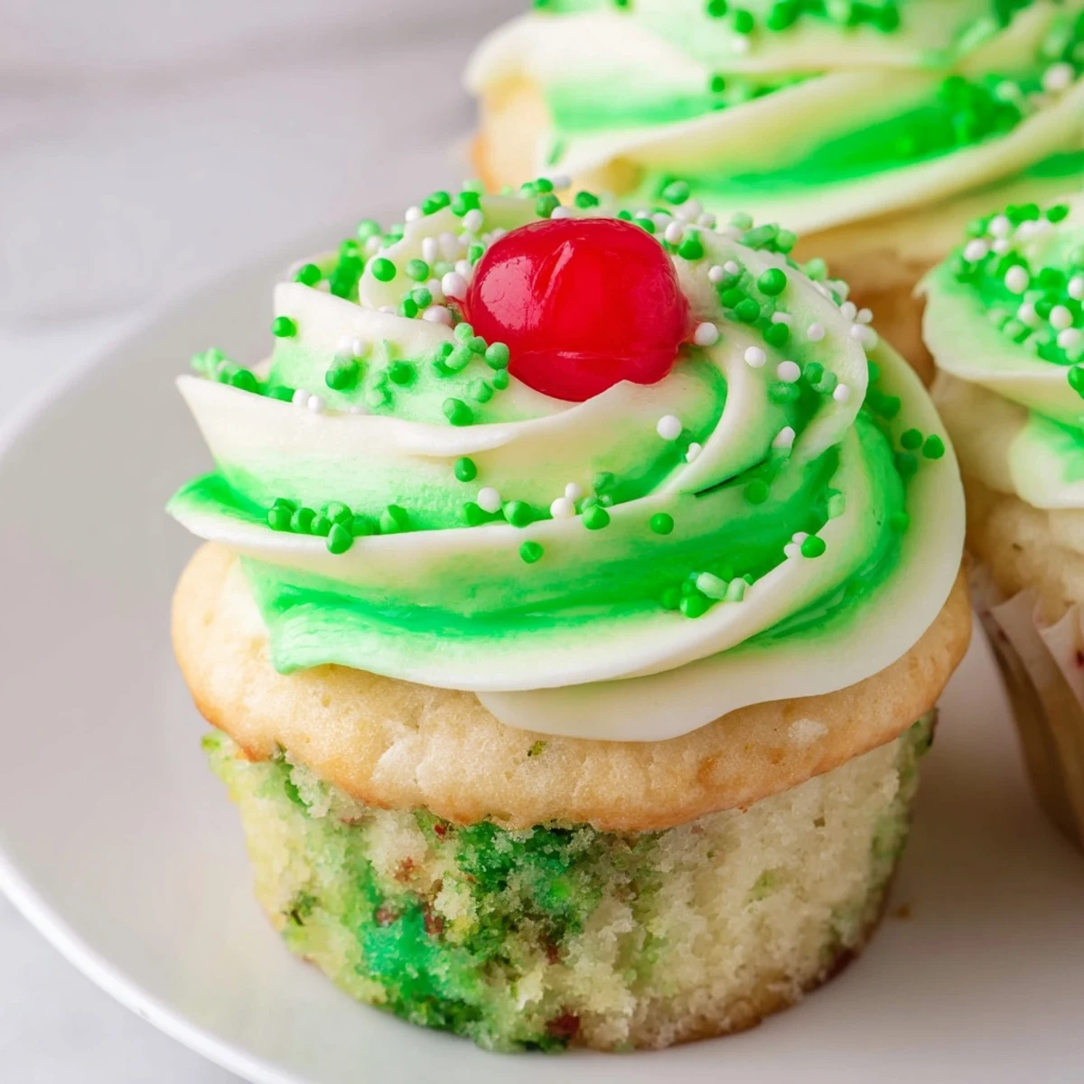 Vibrant green Shamrock Shake Cupcakes with fluffy vanilla cake, creamy mint frosting, and a maraschino cherry on top.  