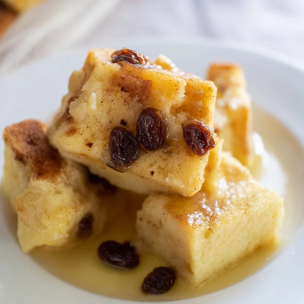 Golden, comforting Bread Pudding with Raisins, showcasing a tender crumb and plump raisins nestled in a rich, spiced custard.