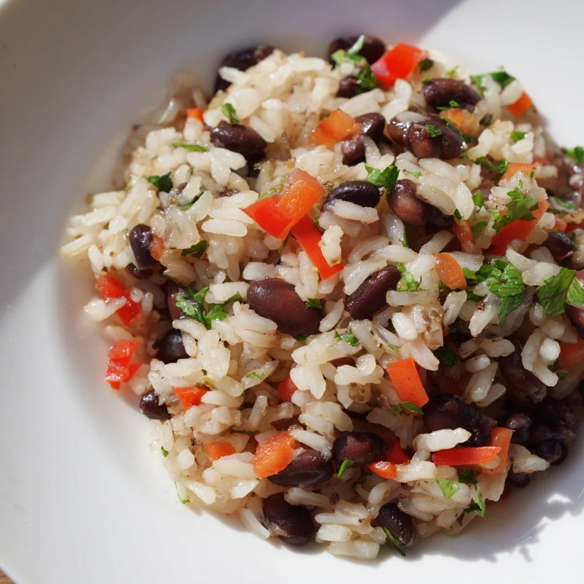Close-up shot of fluffy Rice and Beans with Spices, garnished with fresh cilantro and a lime wedge.