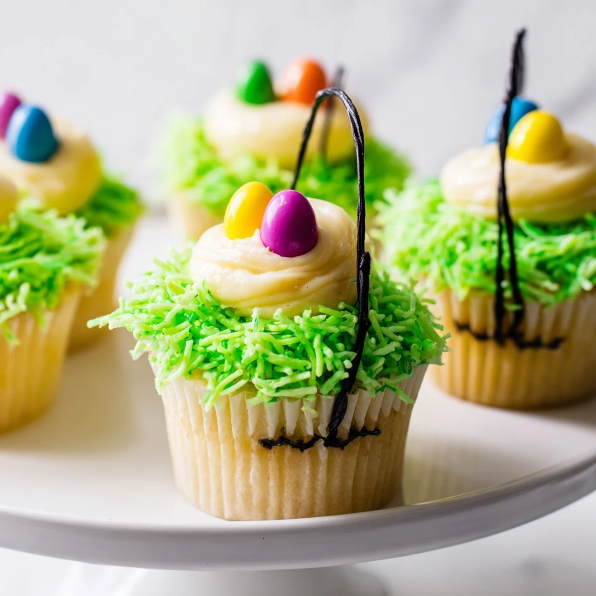 A close-up of Easter Basket Cupcakes with licorice handles and creamy frosting for spring.