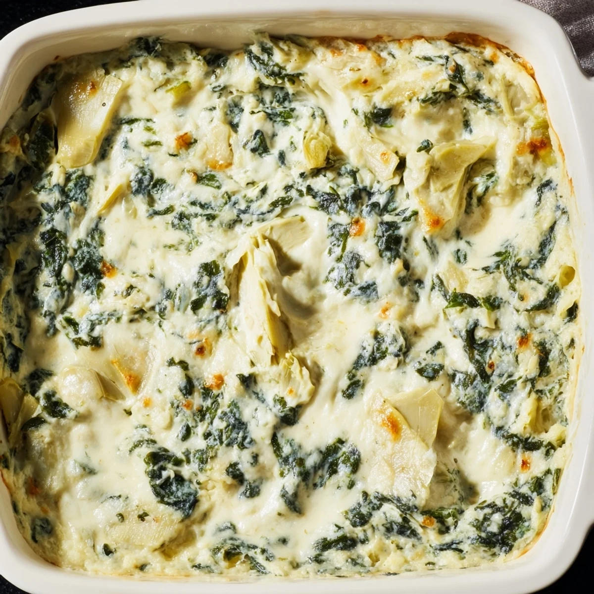 This cheesy spinach and artichoke dip recipe pairs perfectly with crispy tortilla chips for a game day appetizer.