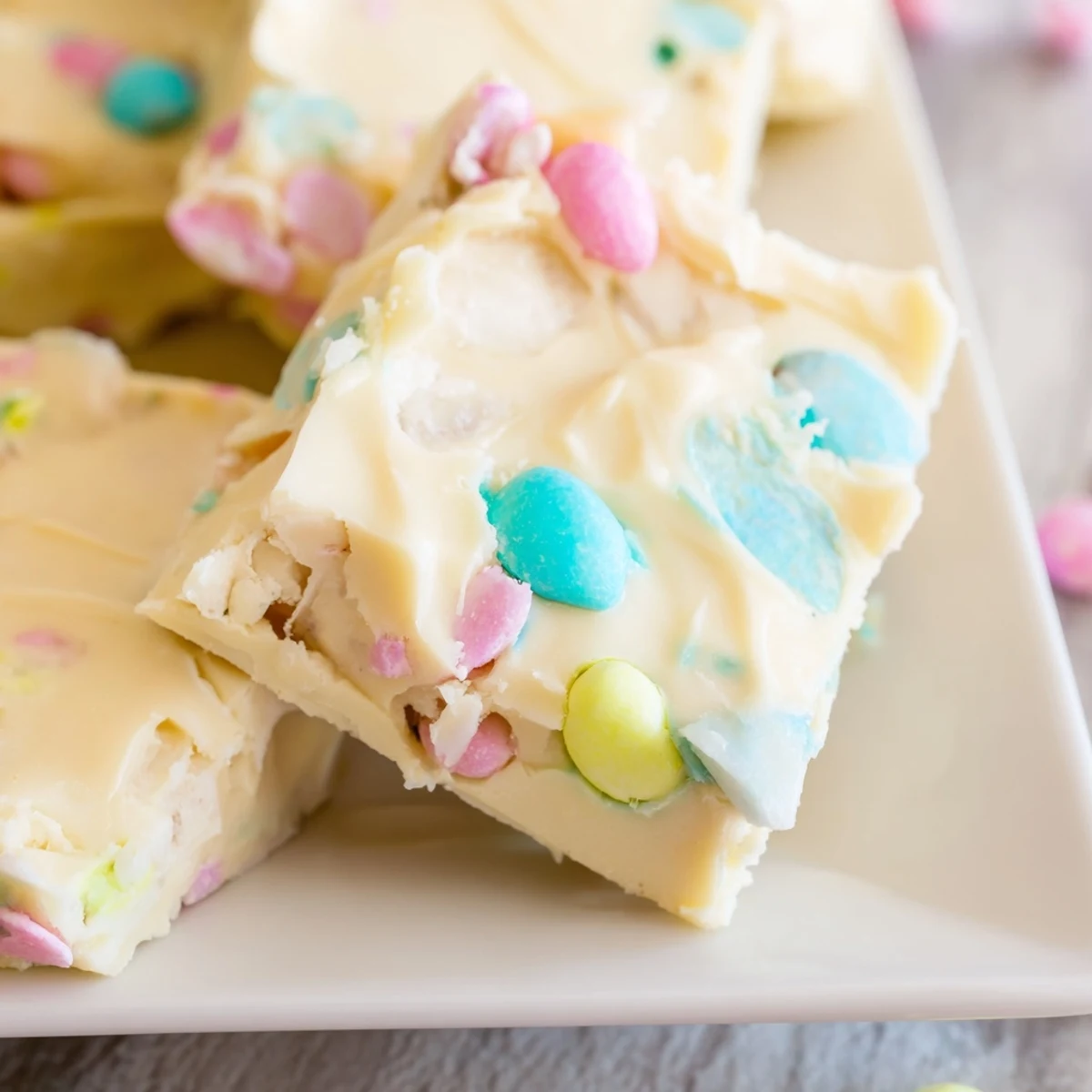 A serving plate of homemade Easter Fudge with smooth texture and festive spring decorations.