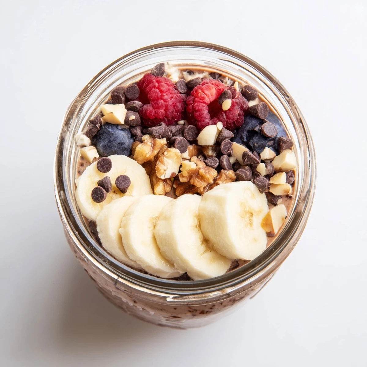 Creamy chocolate overnight oats topped with banana slices and chopped almonds for a wholesome breakfast.