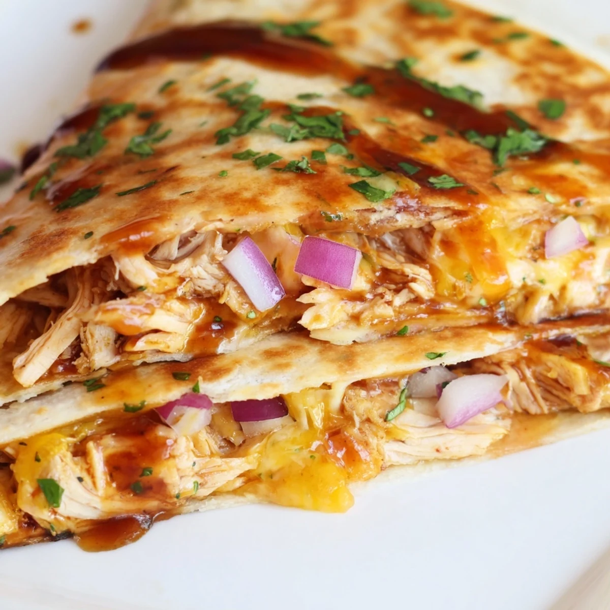 A close-up of Hot Honey BBQ Chicken Quesadillas sliced into wedges, revealing juicy chicken and gooey cheese filling.