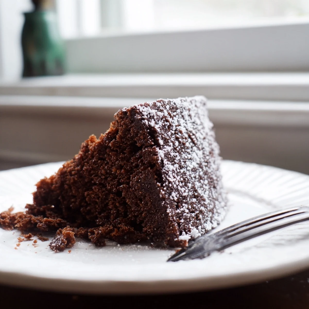 Decadent chocolate stout cake baked in air fryer, garnished with powdered sugar