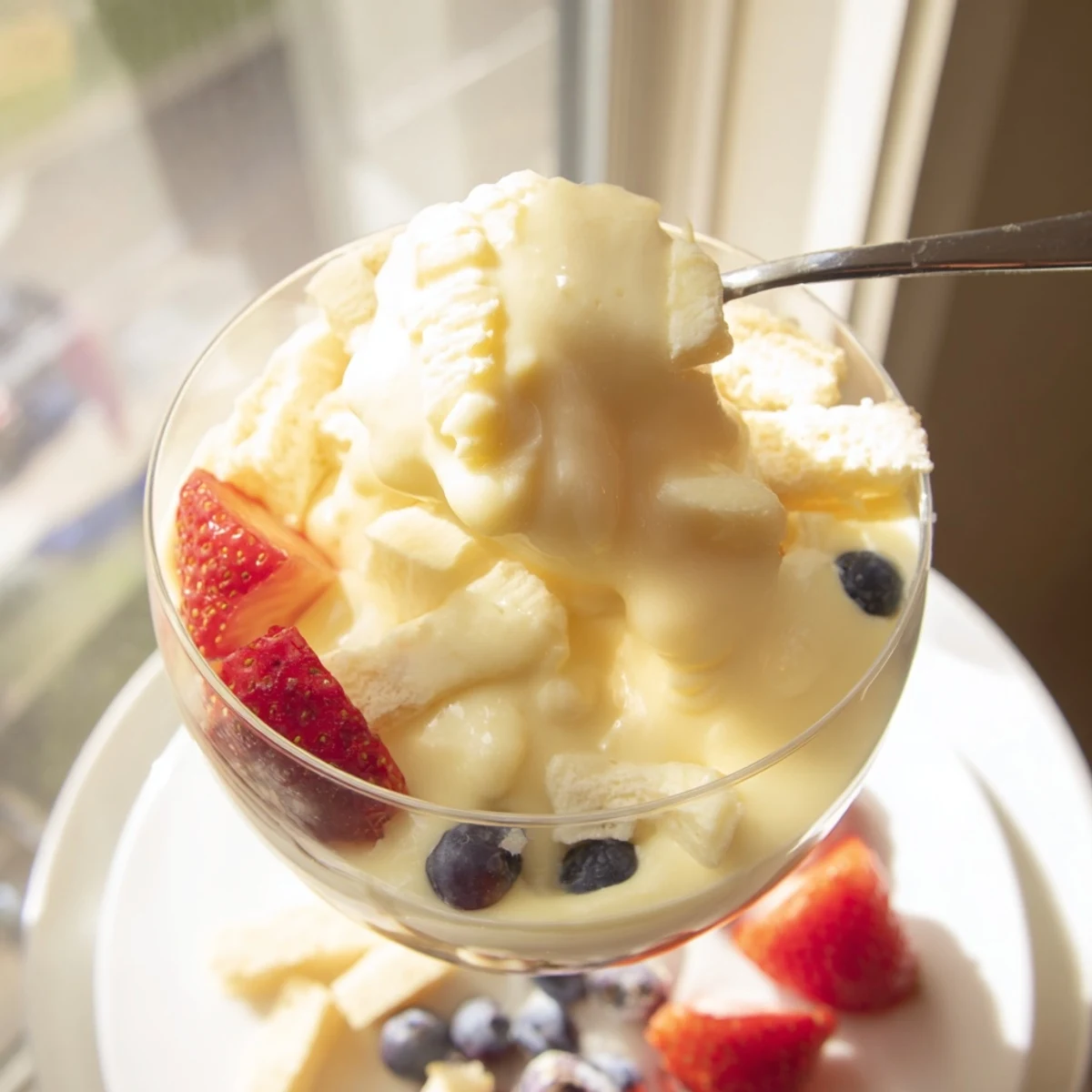 Golden Zabaglione custard served warm in elegant glasses topped with fresh red berries