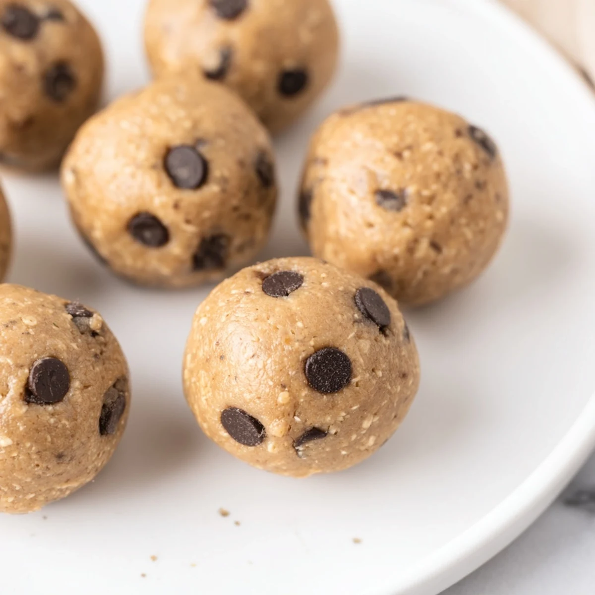 Soft protein energy balls studded with melted chocolate chips resembling classic edible cookie dough bites