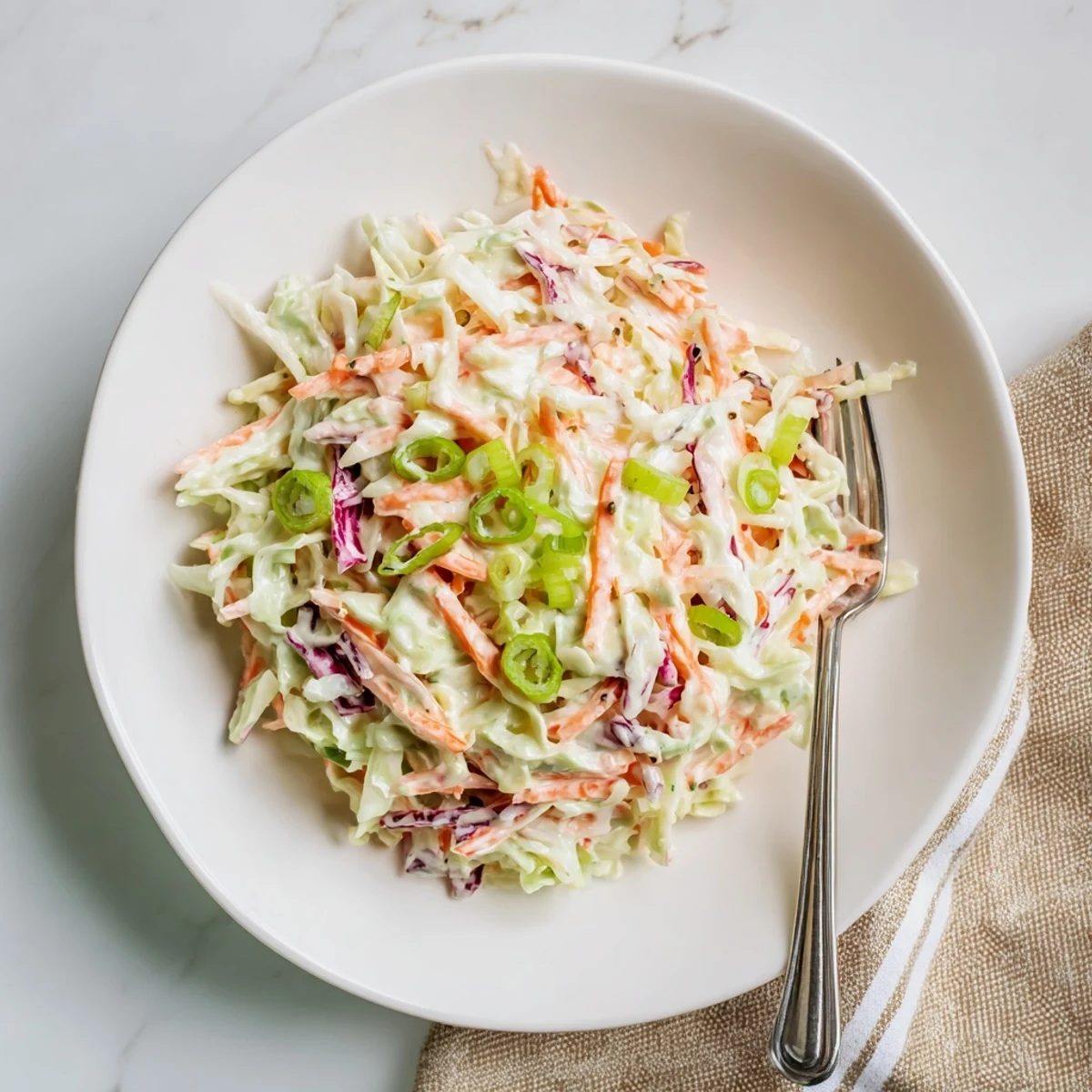 Crisp shredded cabbage and carrots coated in tangy creamy dressing for easy creamy coleslaw