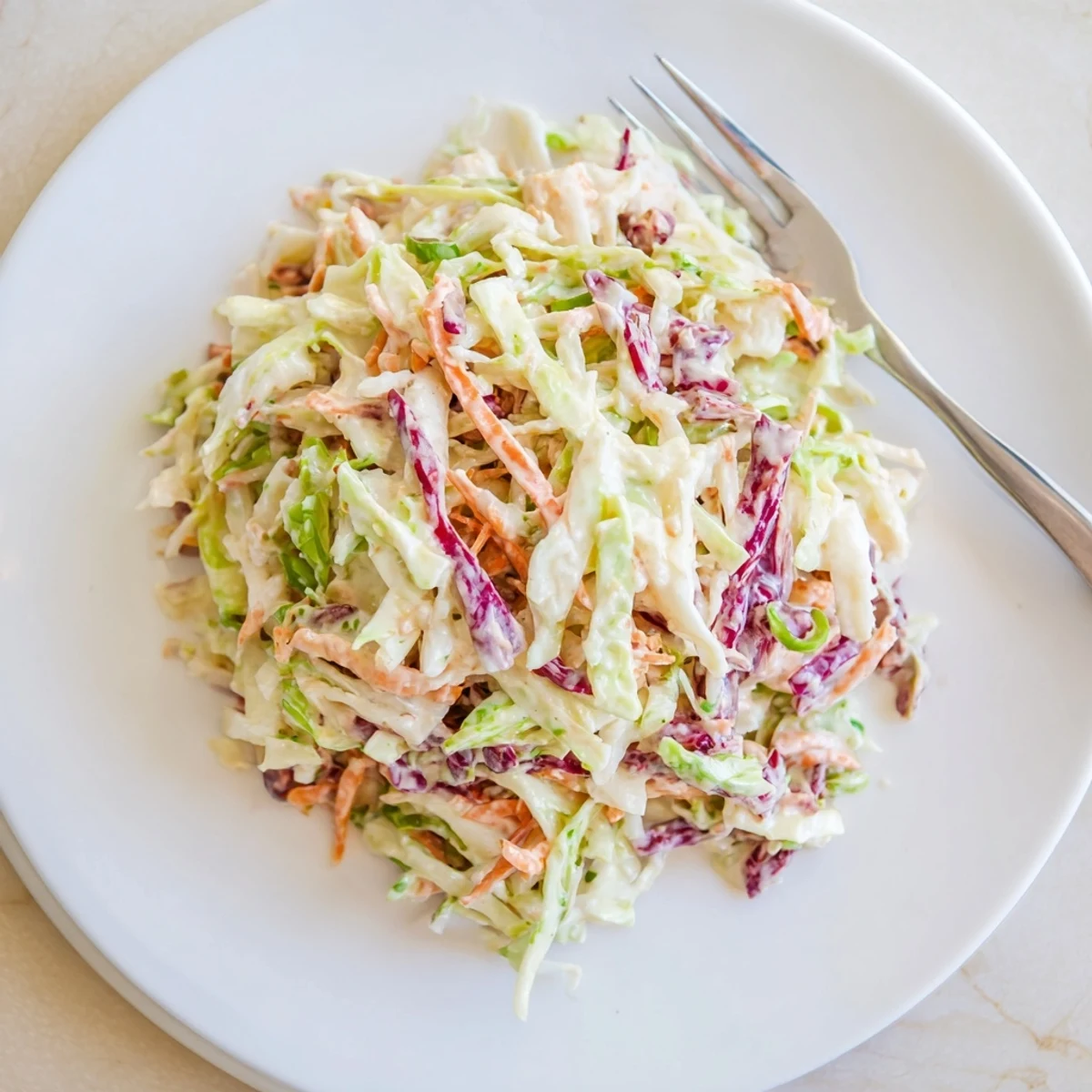 Vibrant purple and green cabbage salad tossed with rich mayonnaise dressing in this easy creamy coleslaw
