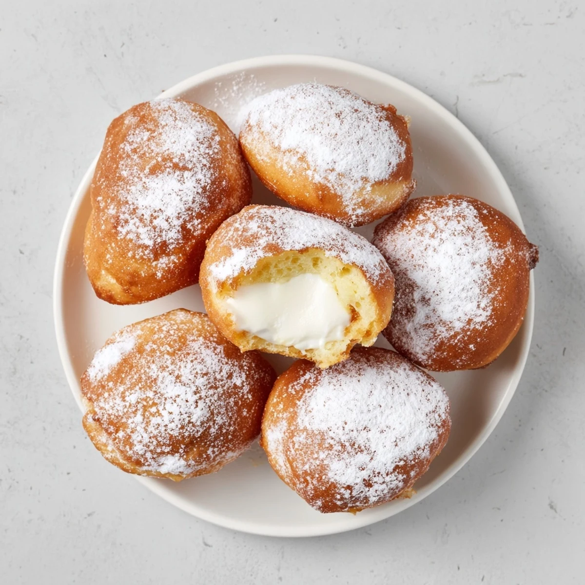 Soft pillowy Korean milk cream donuts filled with sweet vanilla cream sitting on parchment