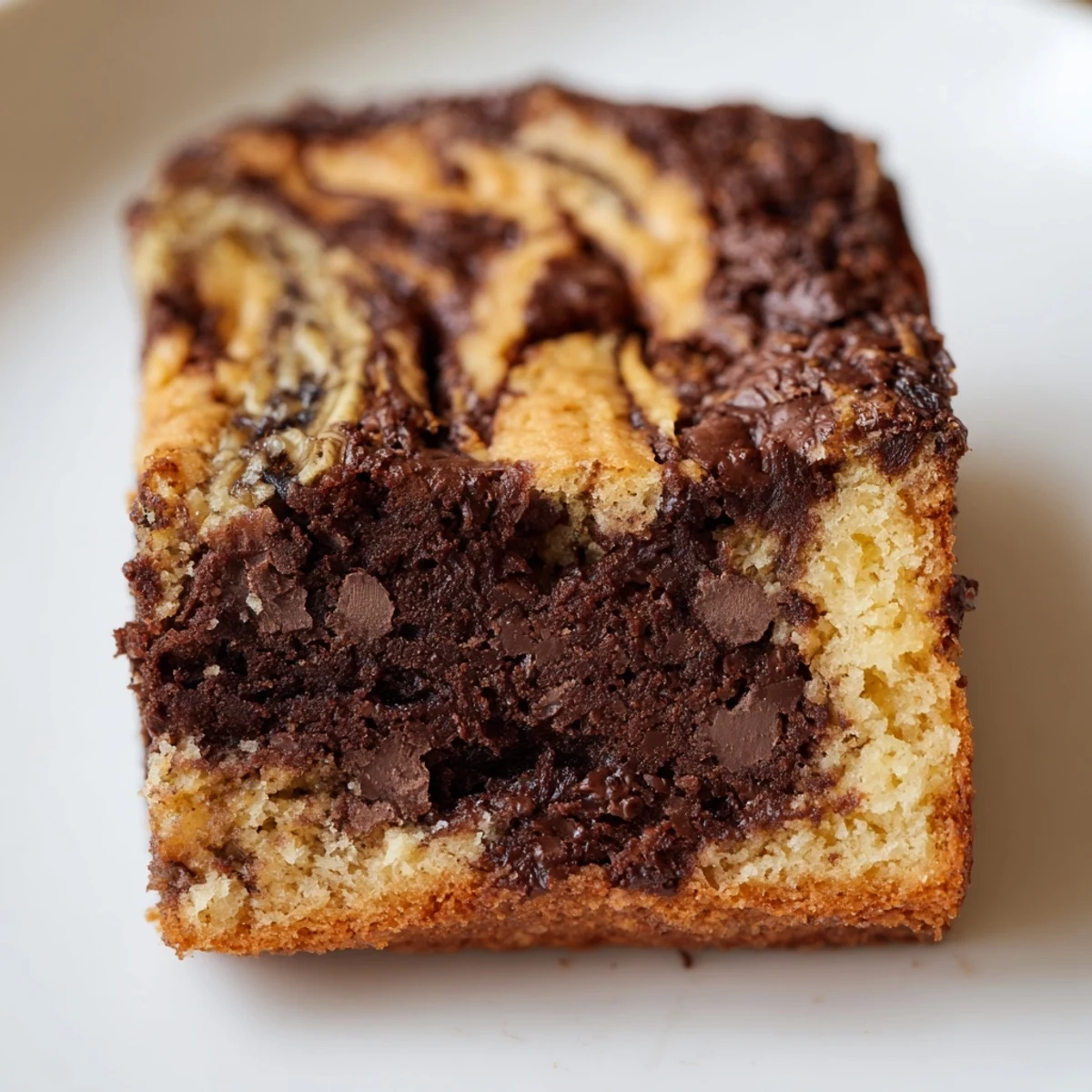 Decadent fudgy brownie swirled with sweet banana batter, sliced into sixteen perfect dessert squares