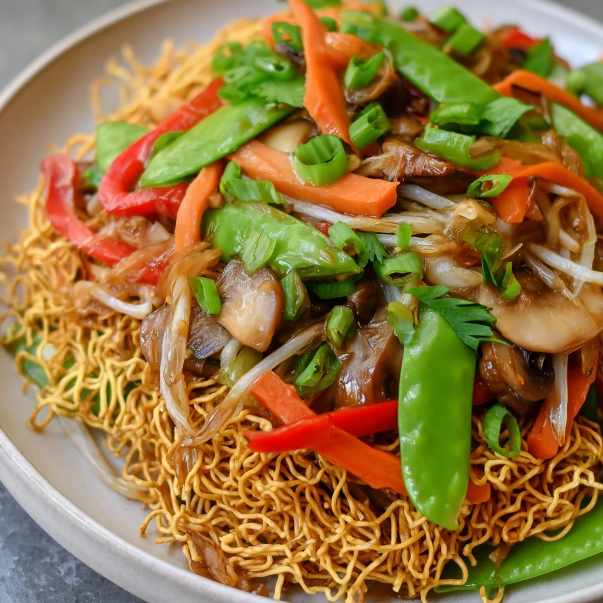 Vibrant vegetable stir-fry served over crispy fried noodles for a satisfying weeknight dinner