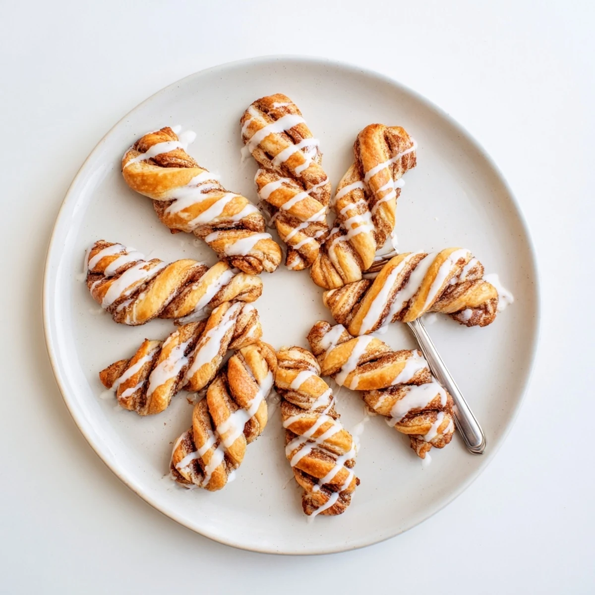 Soft baked pastry twists with swirling cinnamon sugar filling topped with sweet glaze