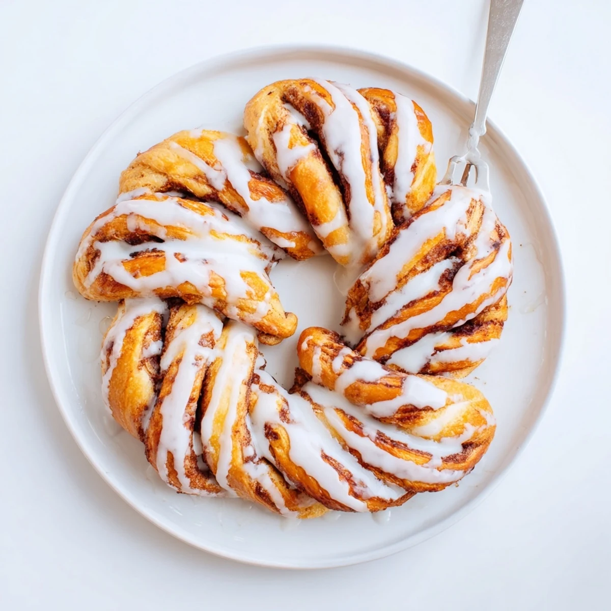 Warm homemade cinnamon twists arranged on a serving board with powdered sugar coating