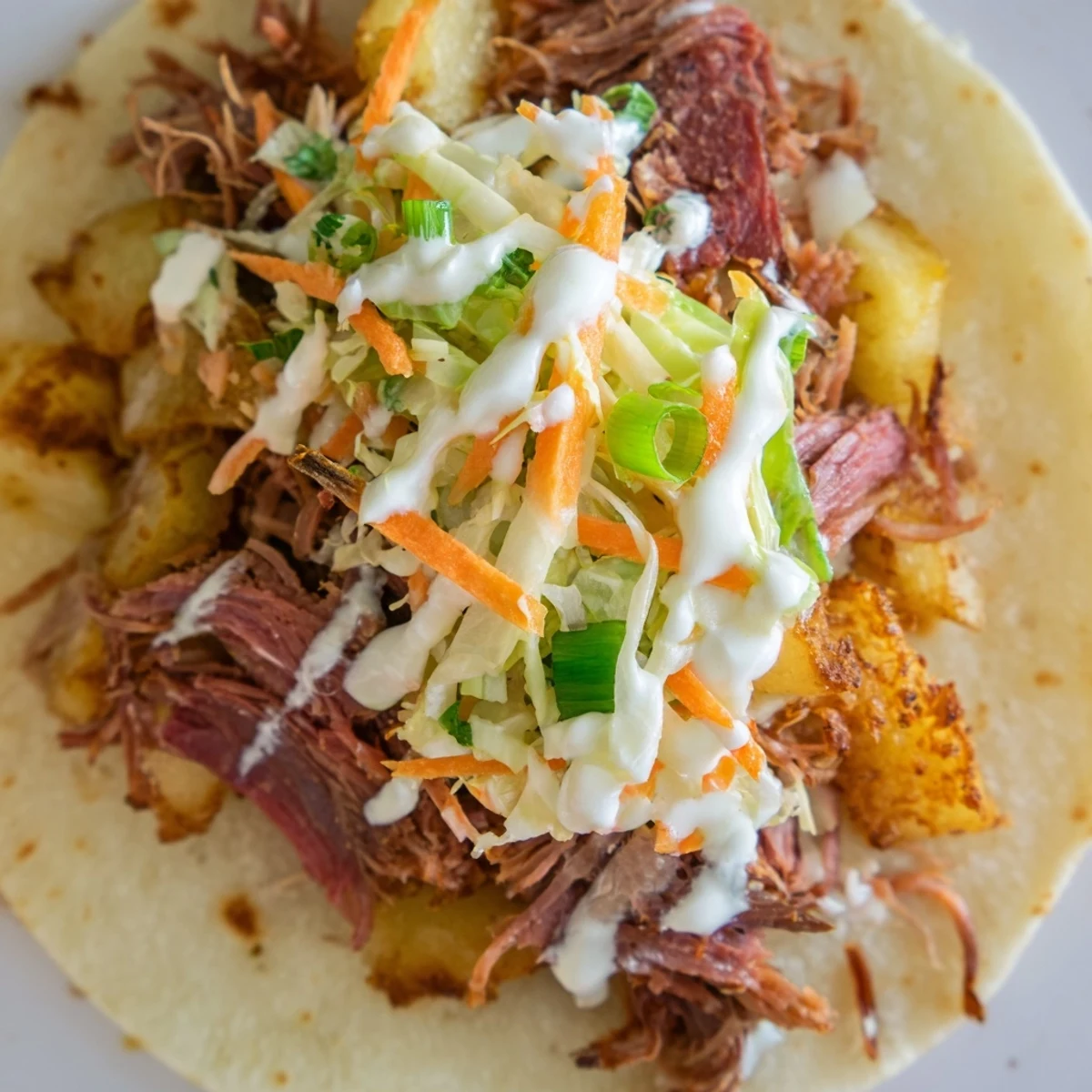 Warm flour tortillas filled with tender corned beef, crispy golden potatoes, and fresh cabbage slaw