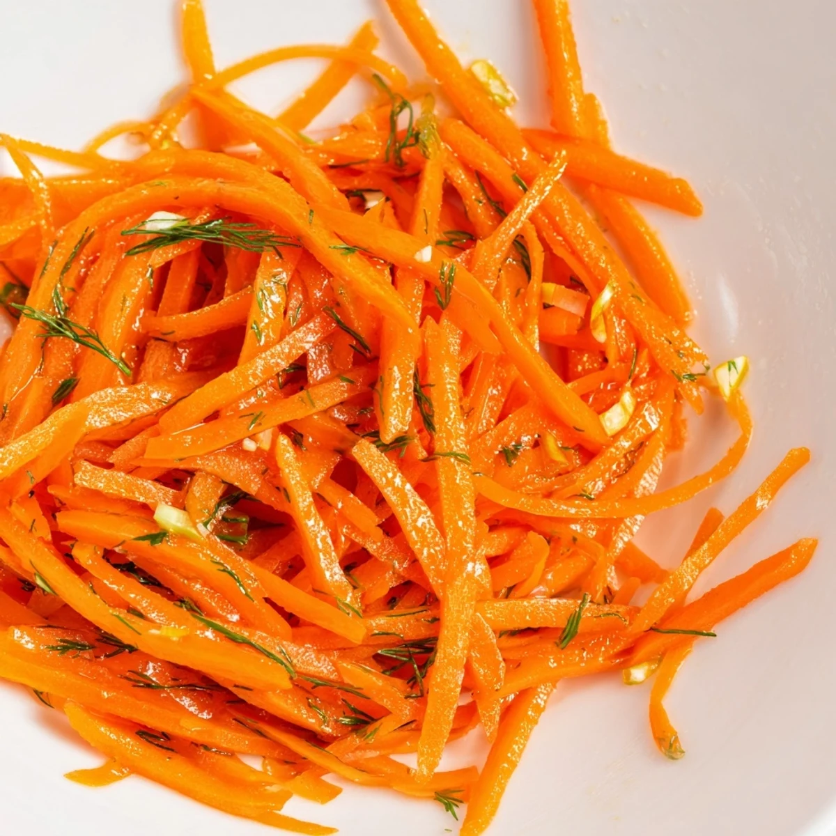 Crisp marinated carrot salad glistening with lemon dill dressing in a rustic serving bowl
