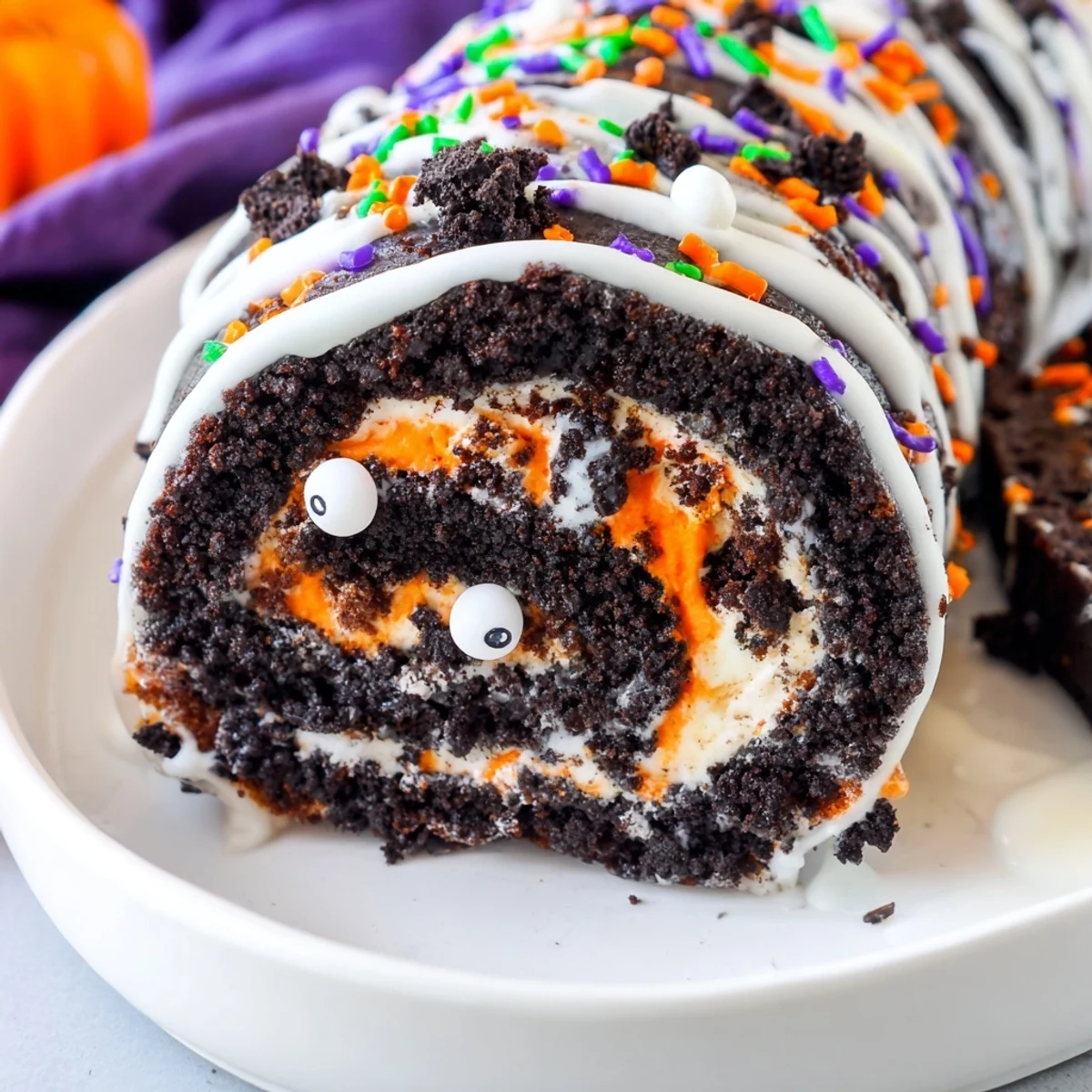 No bake Halloween Oreo Roll swirled with orange whipped cream and candy eyes