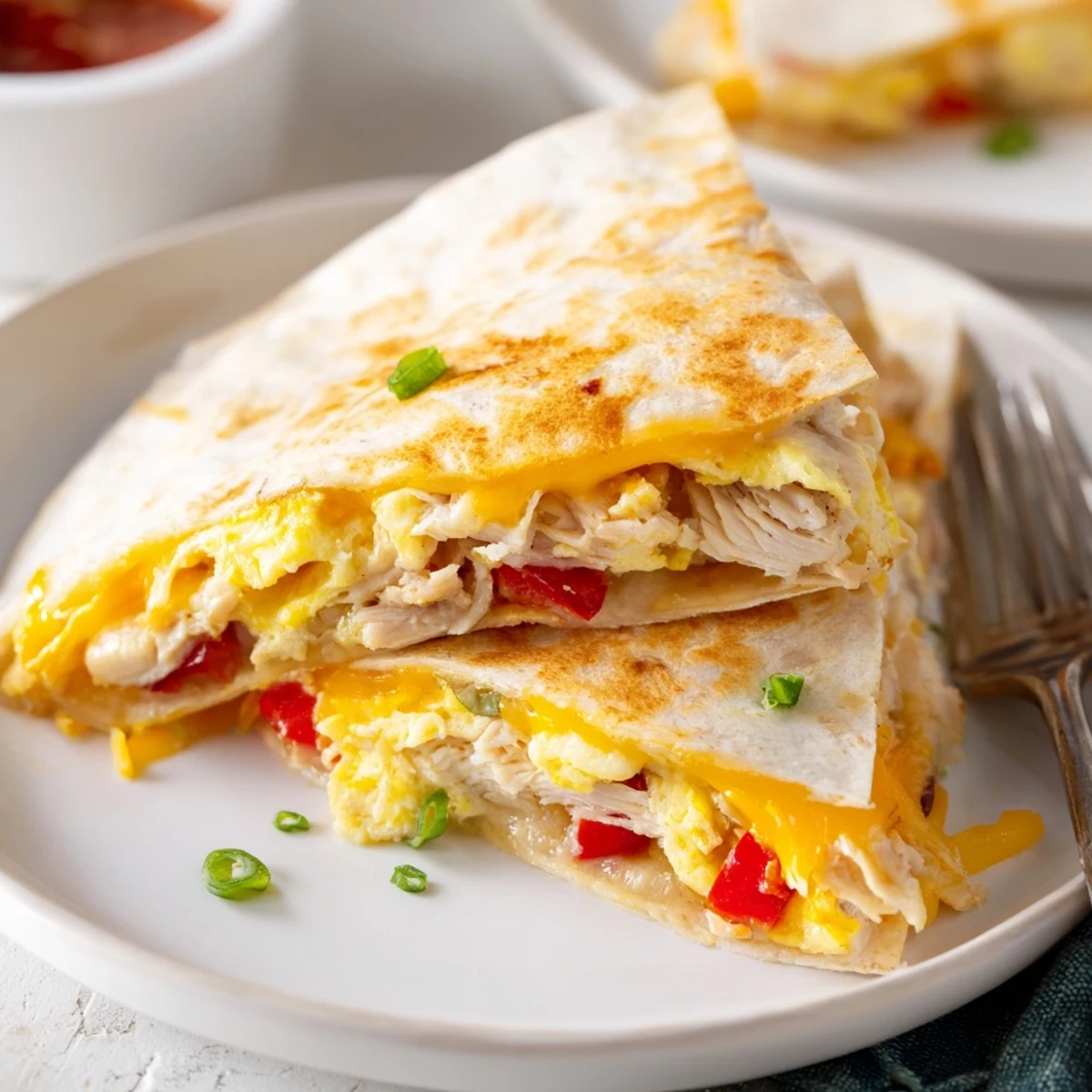 Warm Chicken Breakfast Quesadilla topped with fluffy scrambled eggs and cheddar