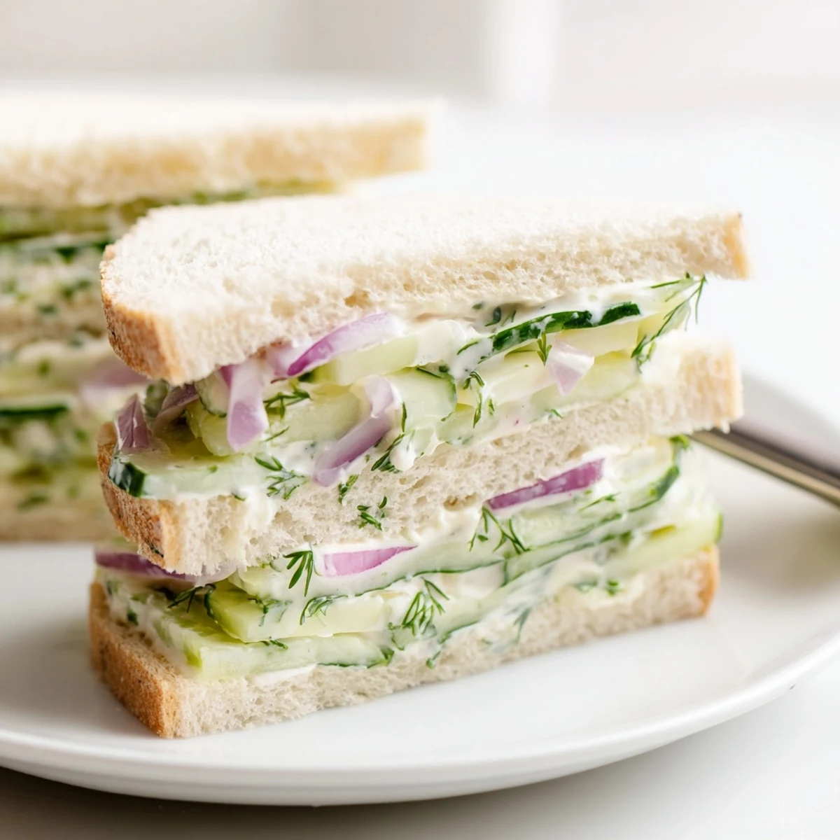 Homemade picnic stack featuring Quick Cucumber Salad Sandwiches, sliced for easy sharing