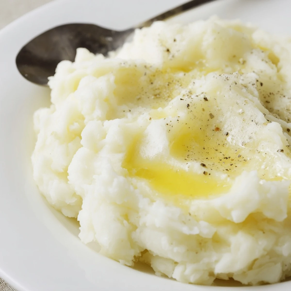 Creamy mashed potatoes steaming in bowl, buttery gloss and fluffy texture