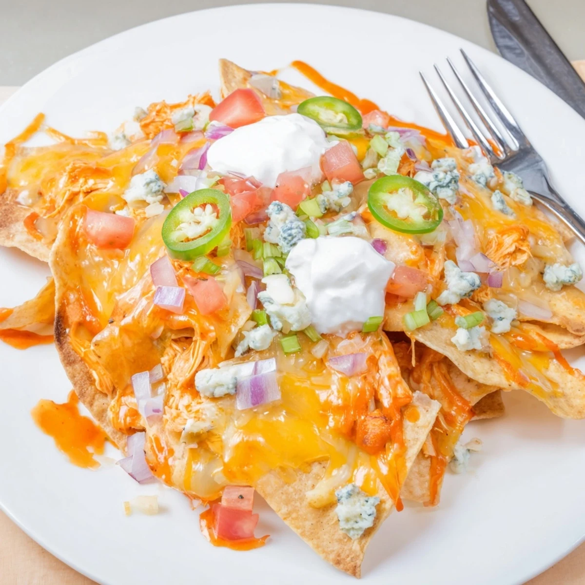 Game-day Buffalo Chicken Nachos: crunchy chips, tangy buffalo sauce, blue cheese crumbles.