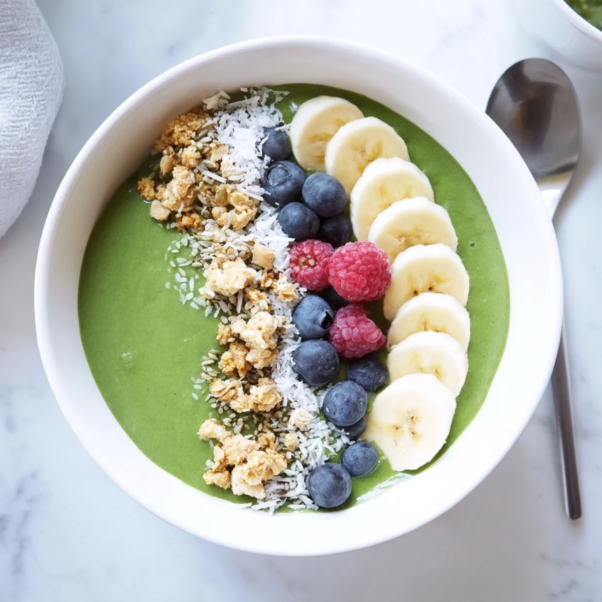 Green Smoothie Bowl With Spirulina, Banana & Hemp Seeds topped with crunchy granola