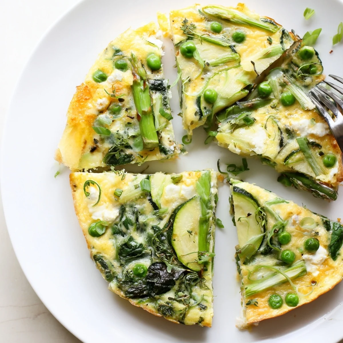 Spring Vegetable Frittata With Goat Cheese, golden top with vibrant asparagus and peas