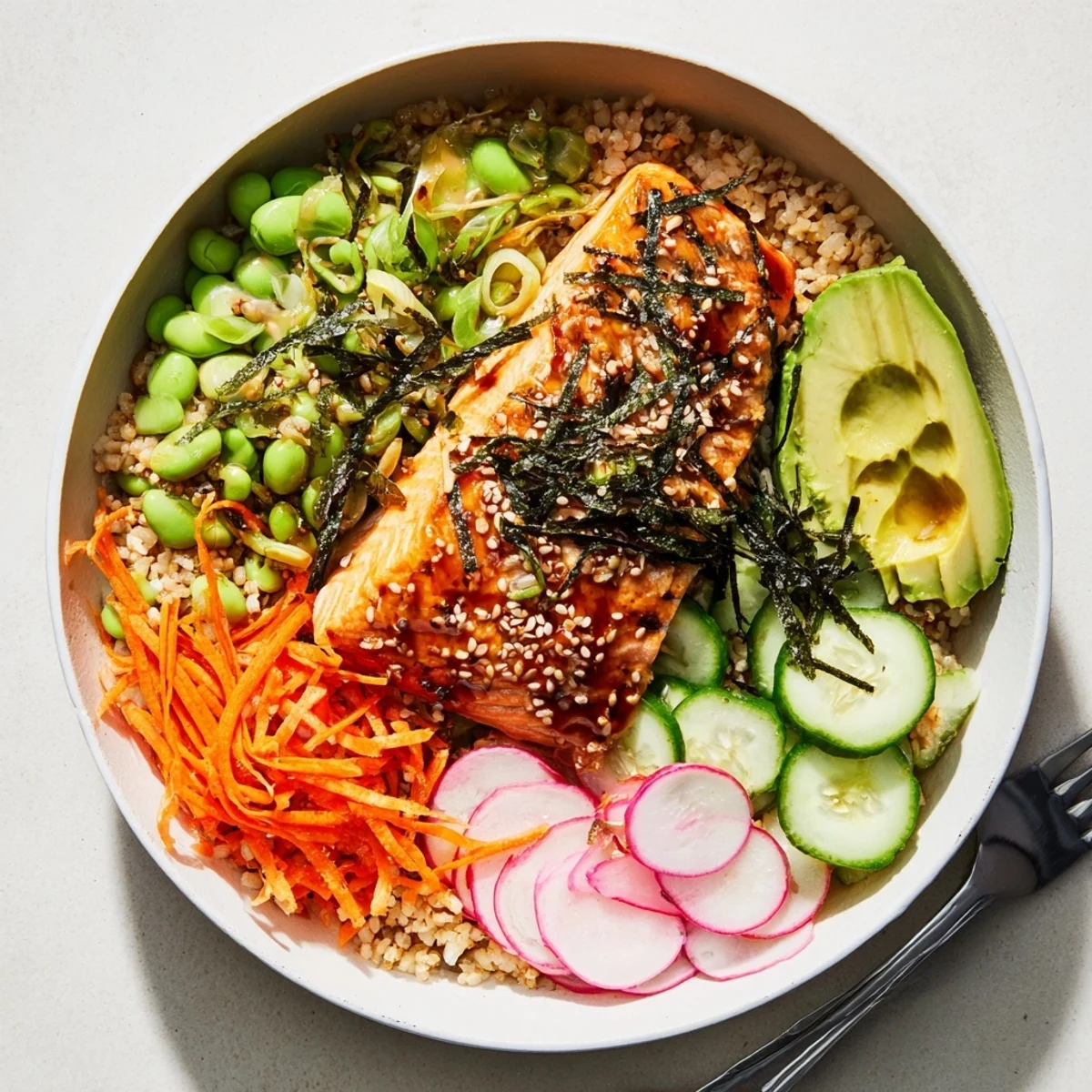 Tender miso-glazed salmon resting on warm grains with crisp cucumber and avocado