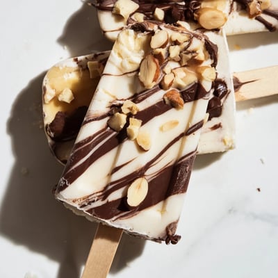 Frozen chocolate banana bliss popsicles drizzled with melted dark chocolate ribbons