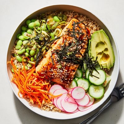 Tender miso-glazed salmon resting on warm grains with crisp cucumber and avocado